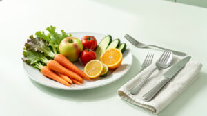 Illustration médicale réaliste d’une assiette de fruits et légumes frais entourée d’ustensiles propres et d’un linge soigneusement plié, évoquant la prévention alimentaire et l’hygiène domestique.