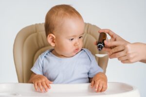 Bébé recevant des gouttes de probiotiques à l’aide d’une pipette.